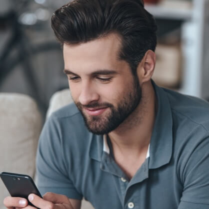 Vīrietis izmanto mobilo telefonu un dalās savā pieredzē par matu tranplantāciju.